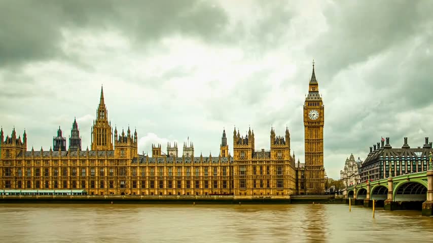 Iconic panoramic view of Big Ben and the Palace of Westminster along the River Thames in London, United Kingdom. The historic Gothic architecture of the Houses of Parliament stands beside Westminster Bridge under a dramatic cloudy sky. Famous British landmark and travel destination, ideal for tourism, cityscape, architecture, history, and travel-related projects.