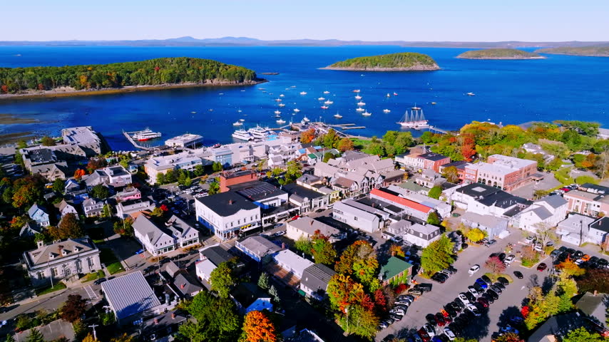 Downtown Bar Harbor brick storefronts in autumn above moored sailboats, Maine