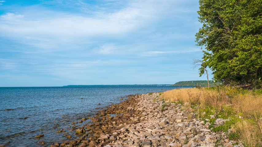 Timelapse Rocky Door County Wisconsin beach with moving cloudy sky