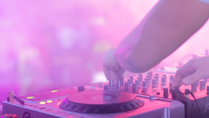 Hands of disc jockey playing set in disko house during music party