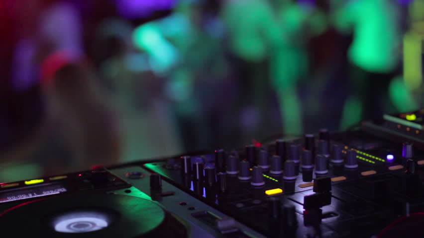 Equipment of DJ, male hands control audio while people dance relax on dancefloor