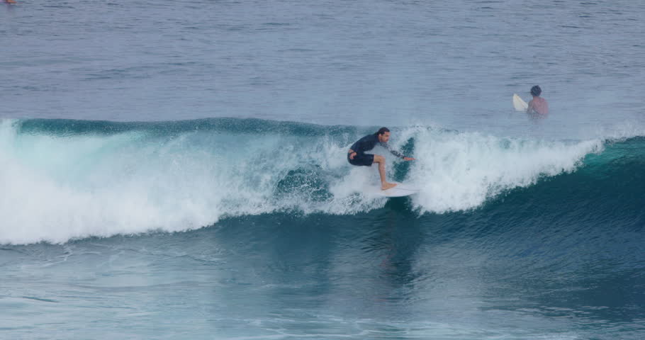 Surfer man riding on ocean wave. Surfing in Bali