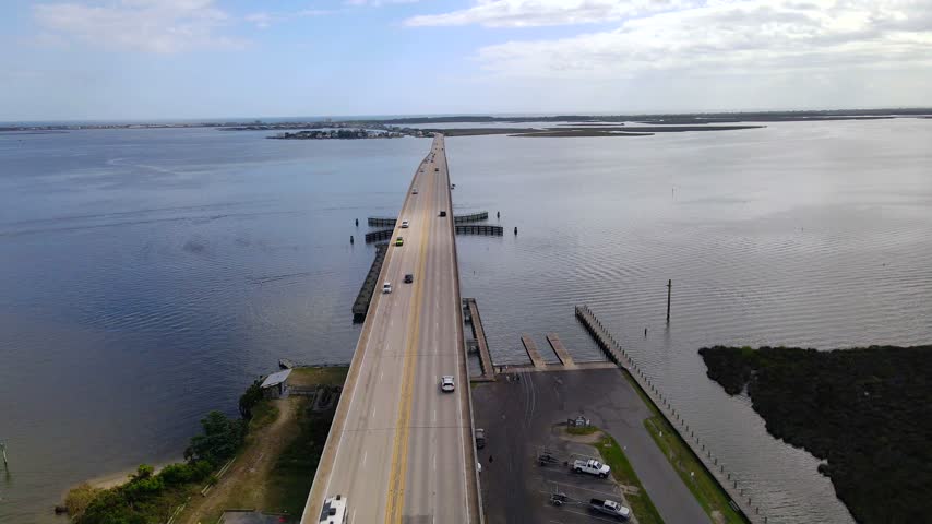 Cars approach and recede along the bridge spanning water near Roanoke Island.