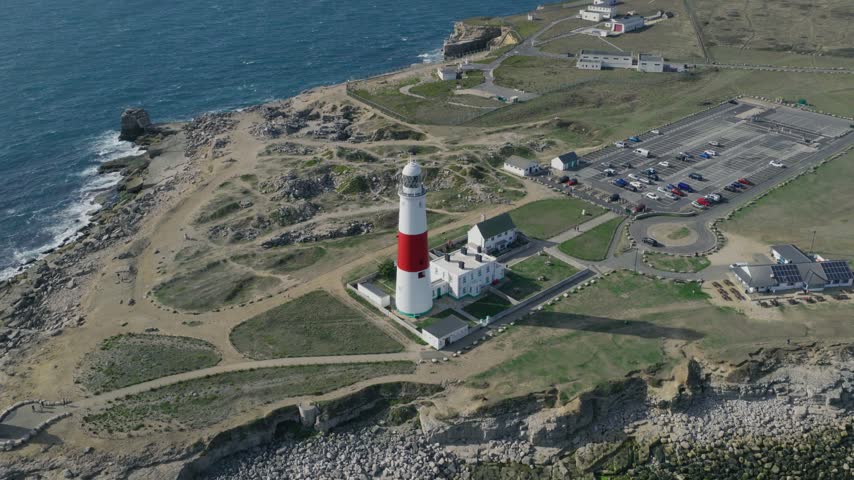 Aerial view of Portland Bill Lighthouse on the Isle of Portland showing the lighthouse complex rocky headland coastline and surrounding visitor area