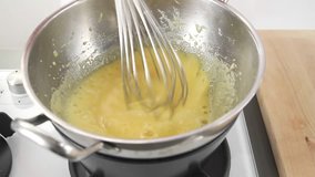 Egg cream being stirred over a double boiler