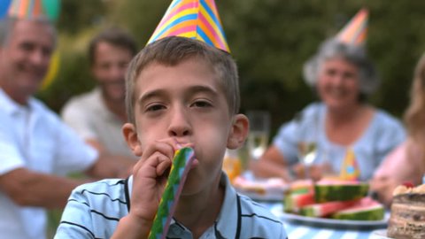 Little boy blowing party horn in slow motion