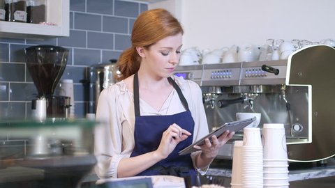 Barista using digital tablet in cafe