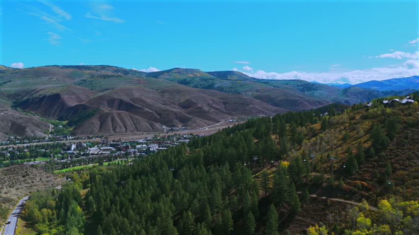 Aerial drone view of Beaver Creek Ski Resort Arrowhead I-70 highway Gore Range sunny blue sky morning Fall Autumn Bachelor Gulch Vail Eagle Avon Edwards Colorado landscape Eagle County upwards motion