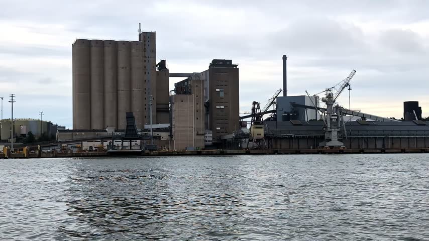 Industrial harbor silos and cargo cranes standing along the coast in Naantali, Finland