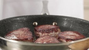 Beef steaks being fried in a pan