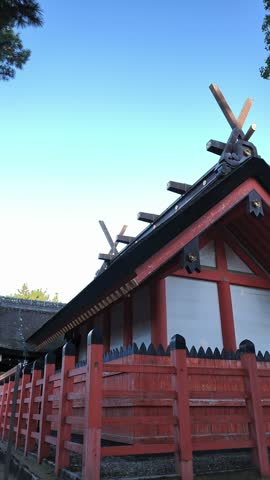 Shrine roof with crossed finials behind a red fence, Sumiyoshi Taisha, Osaka, Japan