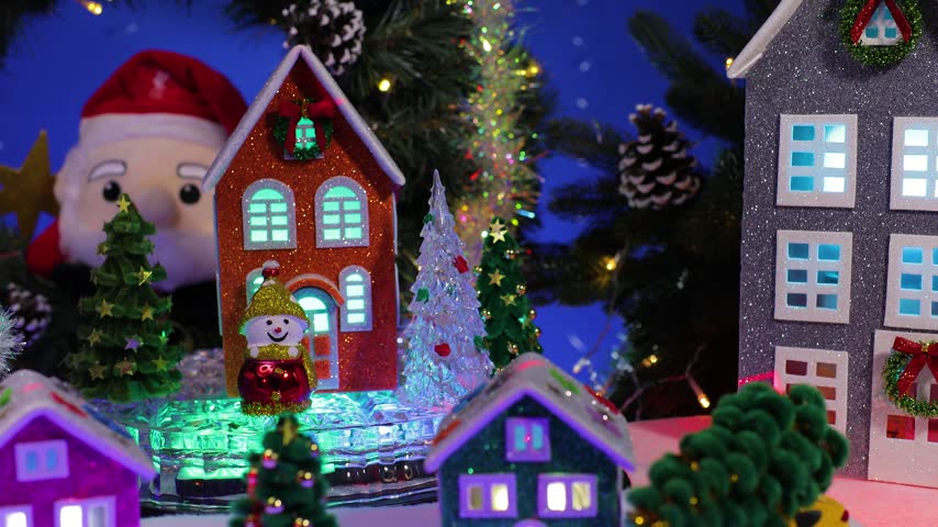 In the Christmas village, near the Christmas wreath, there are colorful little houses