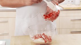 Strawberries being added to cream and mixed