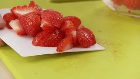 Strawberry pieces being put into a bowl