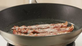 Rashers of bacon being dried on kitchen paper