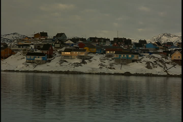 Small colorful houses on the snowy coast of Greenland.