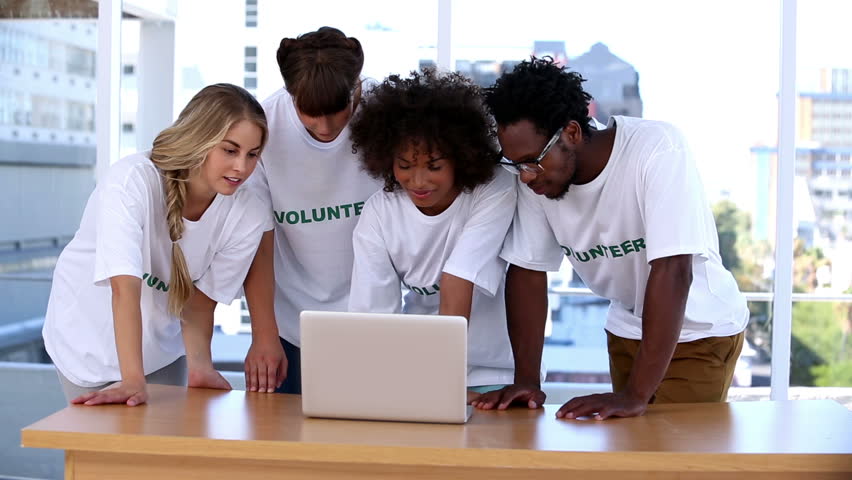 Group of young volunteers using laptop together
