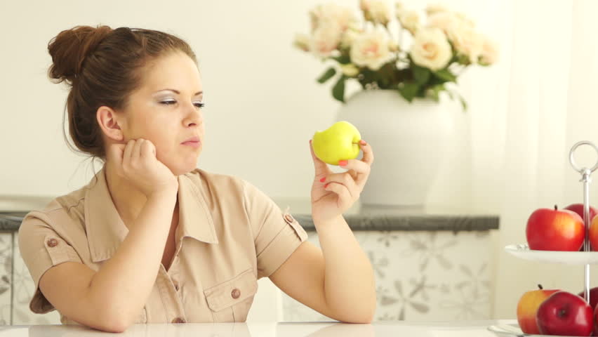 Teenager eating apple and looking at camera with smile
