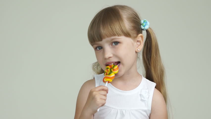 Cute girl licking a lollipop and smiling
