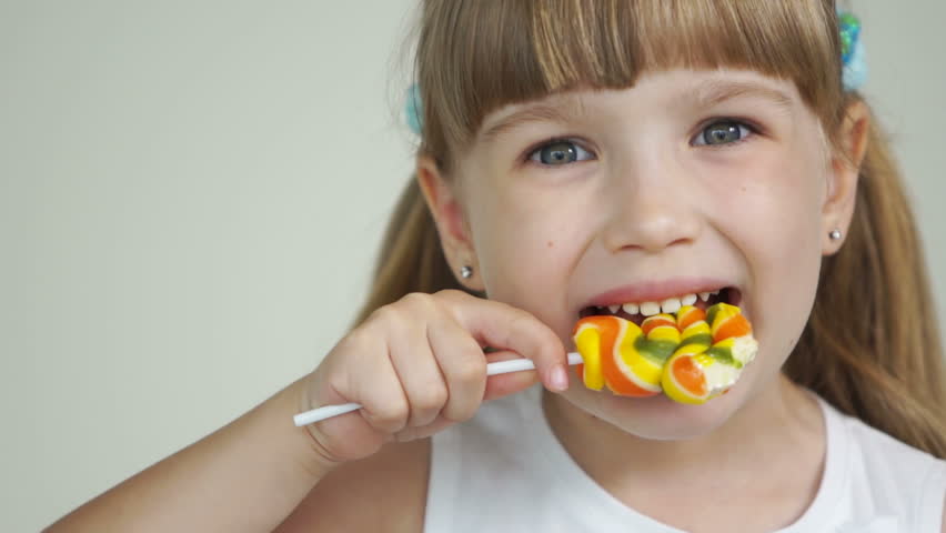 Girl biting a lollipop and smiling
