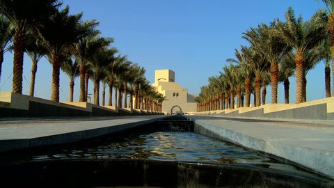 Channel of clear running water in avenue of palm trees in front of Islamic Museum of Art, Doha, Qatar