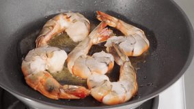 Frying and turning prawns in a pan