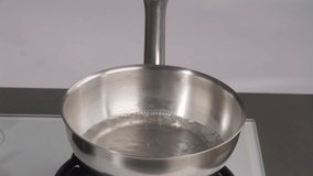 Placing a bowl of chocolate coating over a pan of simmering water