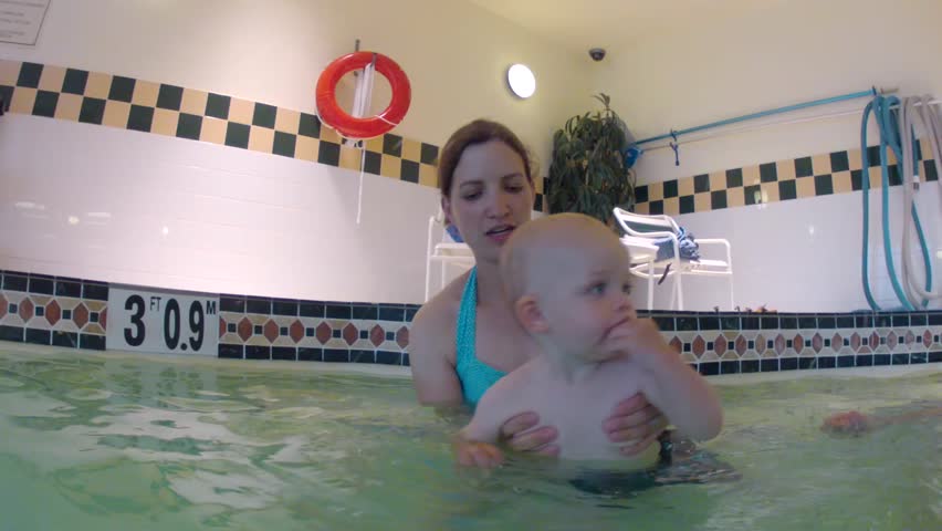 An underwater shot of a family with a toddler swimming in a hotel swimming pool