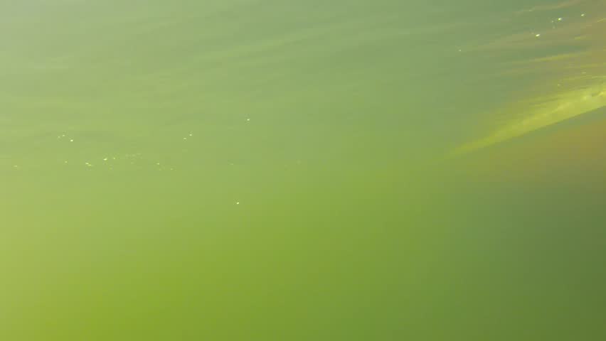An underwater shot of a fishing boat sailing through the ocean