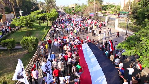 CAIRO, EGYPT - 2013: Protestors march and carry a large flag in Cairo, Egypt.