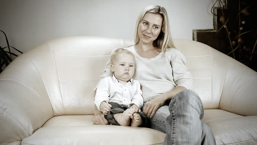Mother with son on sofa watch TV 