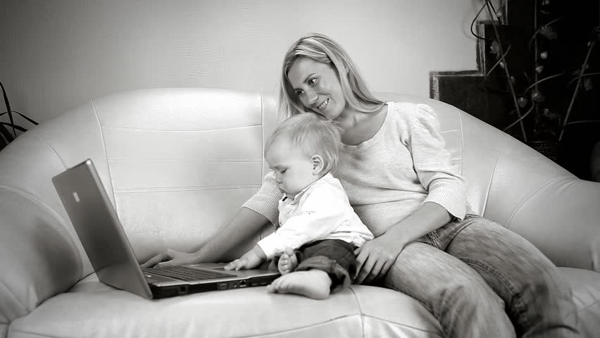 Beautiful son and mother on sofa with the laptop