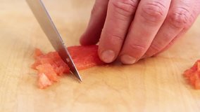 A peeled tomato being diced
