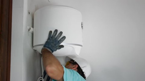 plumber installing an electric water heater