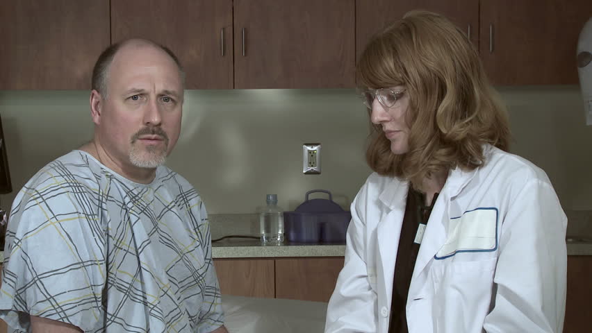 Female doctor gives an injection, possibly a flu shot, to a mature male patient.