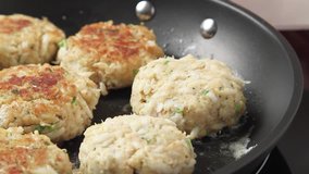 Crab cakes being fried in a pan