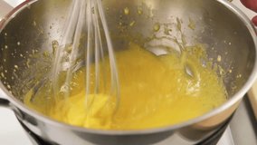 Egg yolk cream being beaten in a double boiler