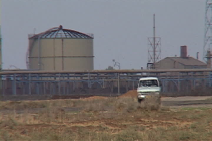 White truck drives past storage tanks at oil refinery in Kirkuk, Iraq.
