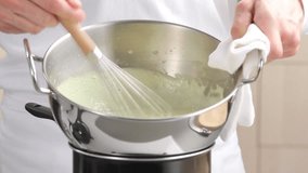 Beating cream in bowl over pan of simmering water