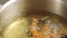 Removing deep-fried prawns from oil