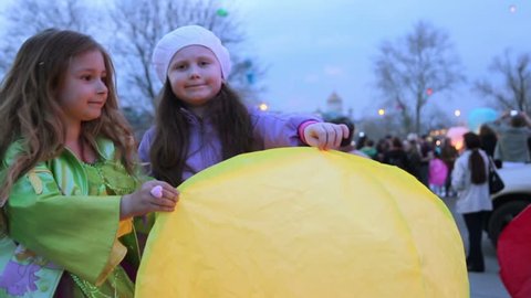 Two little girls hold japan lantern before launch it to heaven at evening in city 스톡 비디오