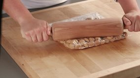Amaretti in a plastic bag being crushed with a rolling pin