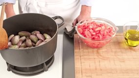 Diced tomatoes being added to fried shallots