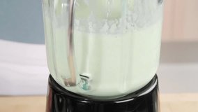Yogurt and cucumber being pureed in a blender