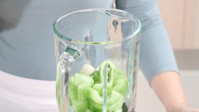 Yogurt being added to cucumber in a blender