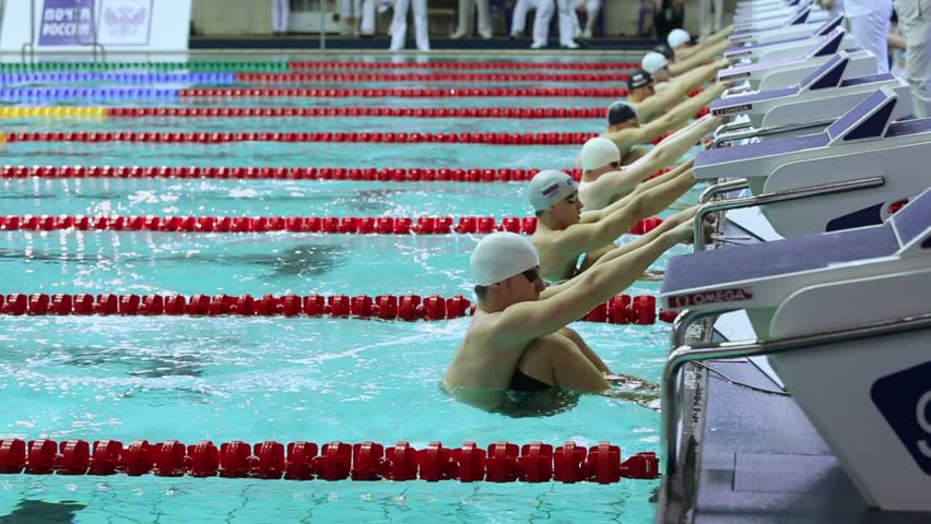 MOSCOW - APR 20: Swimmers jump into water during start of swimming on back in pool at Championship of Russia in Olympic Sports complex on April 20, 2012 in Moscow, Russia