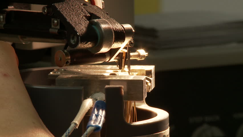 Detail of an electronic component being wired up in a specialized holder.
