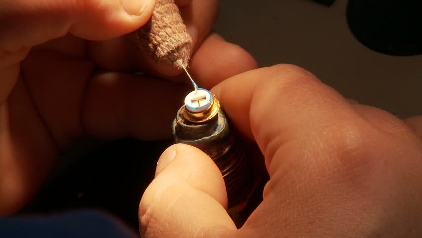 Detail of a hand putting together an electronic component.
