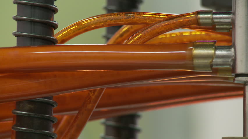 Detail of sauce flowing through bright orange tubing.
