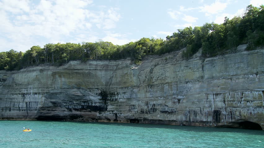 Canoes passing the huge cliffs at Pictured Rocks National Lakeshore park,